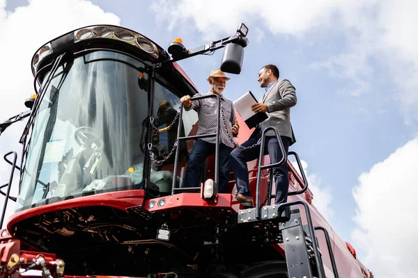 Traktorin Myyjä Esittelee Uuden Yhdistetyn Koneen Harvesterin Mahdolliselle Ostajalle Jälleenmyyntisopimuksessa — kuvapankkivalokuva