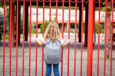 Sırt çantası taşıyan ve okula giden bir kız..