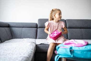 Okula gitmeden önce kalem kutusu hazırlayan tatlı kız..