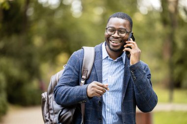 Parkta telefonda konuşan mutlu iş adamı..