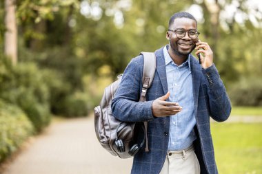 Kulaklıklı, müzik dinleyen, yürürken şarkı söyleyen ve dans eden mutlu bir adam..