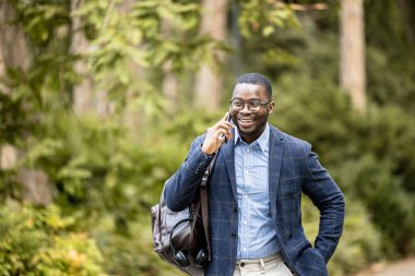 İşe yürüyerek giden ve telefonda konuşan zarif bir adam..