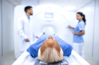 Doktorlar hastayı MRI tanı merkezinde tam vücut tarama prosedürüne hazırlıyorlar..