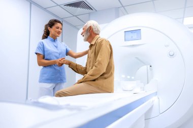 MRI teknisyeni hastayı hastanede taramadan önce teşvik ediyor..