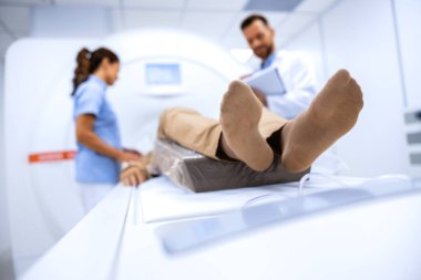 Doktorlar hastayı MRI tanı merkezinde tam vücut tarama prosedürüne hazırlıyorlar..
