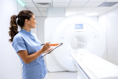 MRI tarama odasında duran kadın radyoloji uzmanı..