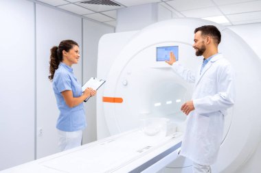 Doktorlar MRI tarama makinesini hastanede kullanılmak üzere hazırlıyorlar.