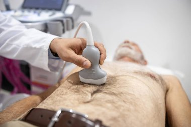Karaciğer, pankreas, safra kesesi, dalak veya böbrek gibi hastanın iç organlarına ültrason yapan bir doktor. Sindirim sisteminin taranması ve tıbbi incelemesi.