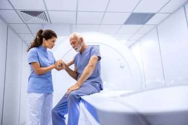 MRI taraması ya da hastanede tomografi çekilmeden önce kıdemli adamı hazırlayan ve cesaretlendiren doktor..