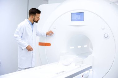 Doktor radyoloji uzmanı hastanede MRI tarama makinesi hazırlıyor..