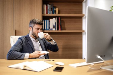 Sıcak bir ofiste oturup kahve içerken mali sonuçları analiz etmek..