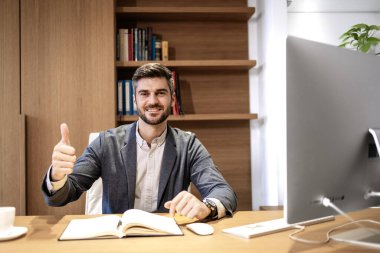 Başarılı yakışıklı iş adamının portresi ofisinde başparmak kaldırıyor..