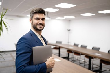 Akıllı iş adamı şirket toplantı odasında duruyor..