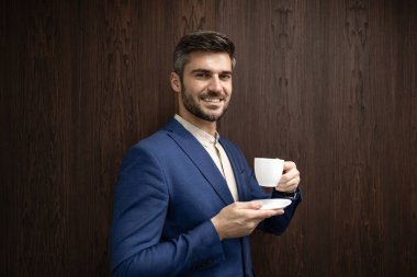 Zarif iş adamı bir fincan kahvenin tadını çıkarıyor..