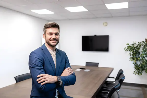 Experienced manager proudly standing in business meeting room.