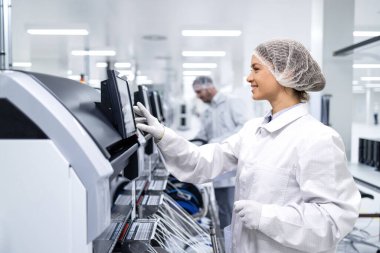 Otomotiv endüstrisinde çalışan özel anti-statik giysili üretim hattı işçisi.