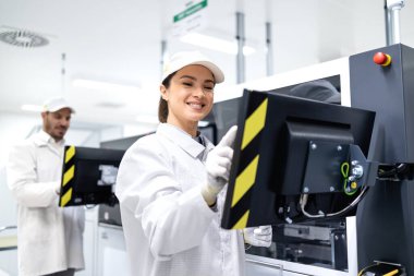 Deneyimli fabrika işçileri modern endüstriyel makineleri çalıştırıyor, otomotiv endüstrisindeki üretim sürecini kontrol ediyorlar.