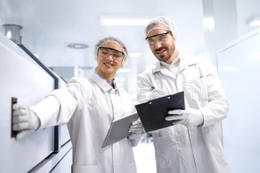 Otomobil endüstrisi için elektronik bileşenlerin kalitesini kontrol eden fabrika işçileri.