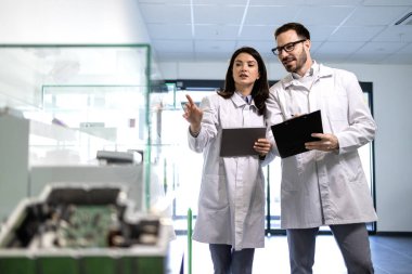 Kalite kontrol uzmanları fabrika sergi odasında yeni ürünleri kontrol ediyorlar.