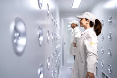 Fabrika işçileri üretim bandına gitmeden önce giysilerinden toz ve parçacıkları çıkarıyorlar..