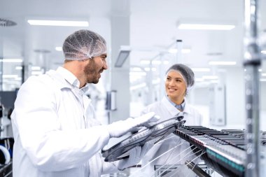 Otomotiv endüstrisinde gelişmiş yarı iletken üretim makinesi kullanan fabrika işçileri.