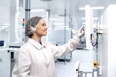 Gıda fabrikasında çalışan ve ambalaj için endüstriyel makine kullanan bir teknoloji uzmanı..