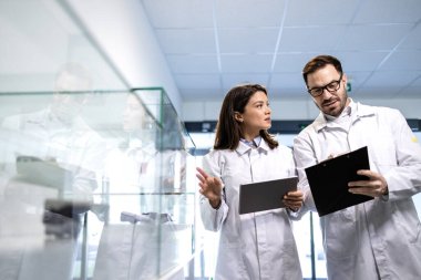 Teknoloji uzmanları fabrika test odasındaki ürün kalitesini değerlendiriyor. Uzmanlar otomobil endüstrisi için elektronik parçaları test ediyorlar.