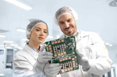 Yazılı devre kartlarını tutan ve elektronik bileşenleri geliştiren mühendislik teknolojisi uzmanı..