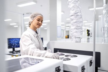 Deneyimli kadın teknoloji bilimci ilaç fabrikasındaki ilaç üretim sürecini kontrol ediyor..