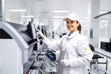 Fabrika içinde gelişmiş endüstriyel makine kullanan kadın üretim hattı işçisinin portresi..