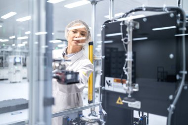 Kadın mühendis elektronik üretim fabrikasındaki yeni nesil makineleri izliyor..