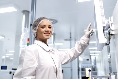 Modern fabrikada üretim sürecini kontrol eden deneyimli beyaz kadın işçilerin portresi.