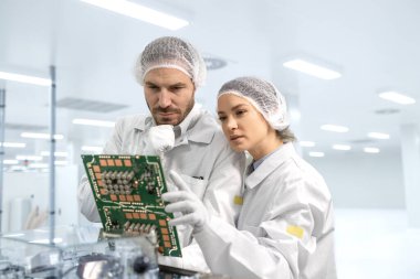 Mühendislik teknolojileri yeni elektronik cihaz geliştirme üzerinde çalışırken işbirliği yapıyor.