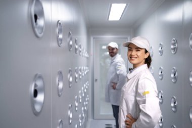 Fabrika işçisi endüstriyel hava üfleme tünelinde duruyor. Üretim hattına girmeden önce toz ve parçacıkları temizliyor..