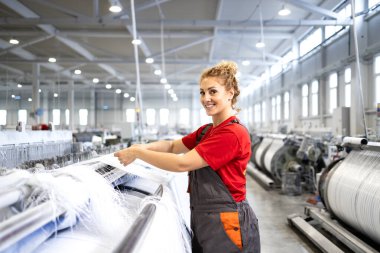 Female worker inside textile factory producing carpets. clipart