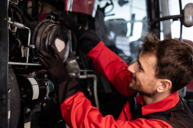 Tarım makinelerinin bakımı ve bakımı. Asker traktördeki kirli ve tozlu hava filtresini kaldırıyor..