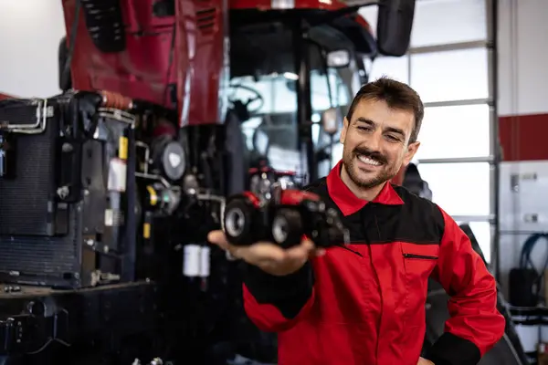Erfarne Serviceman Holder Traktor Model Inde Værksted Royaltyfrie stock-fotos