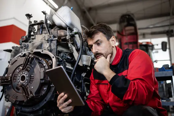 Serviceman Commander Des Pièces Rechange Sur Tablette Réparer Moteur Tracteur Image En Vente