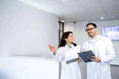 Doktorlar hastanede yürüyorlar ve birbirleriyle konuşuyorlar..