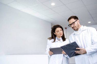 Doktorlar hastanenin içinde hasta ameliyat programını tartışıyorlar..