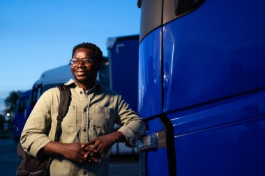 Teslimatçı gece kamyonunun yanında duruyor..