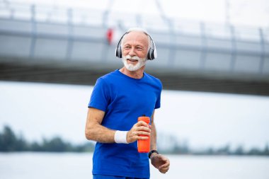 Nehir kıyısında koşan kıdemli adam..