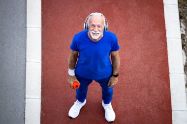 Koşu parkurundaki yaşlı sporcunun üst görünümü.