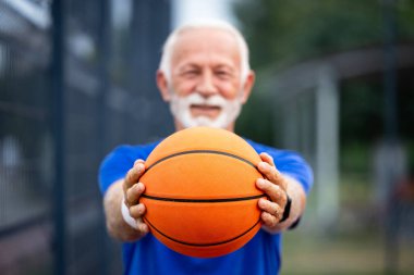 Basketbol topunun yakın görüntüsü ve son sınıf öğrencisi elinde tutuyor. Sporu ve sağlıklı yaşam tarzını desteklemek.