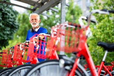 Şehir bisikleti kiralayan yaşlı bir adam..