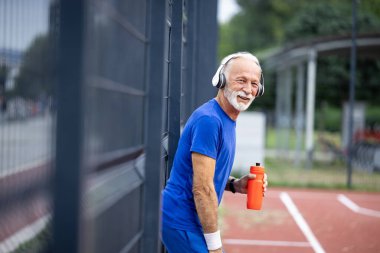 Kıdemli adam antrenmanda su içiyor..