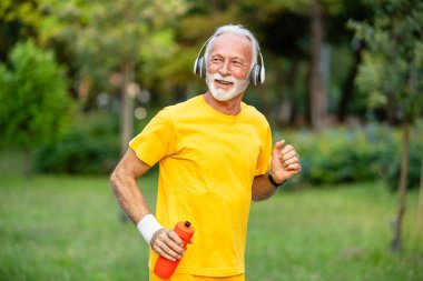Aktif kıdemli adam sağlık için koşuyor ve eğitim görüyor..
