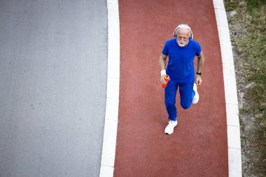 Emeklilik döneminde hipodromda koşan son sınıf öğrencisi. Sağlıklı yaşam için eğitim.