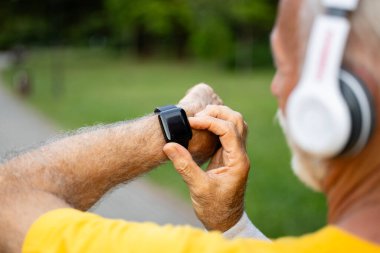 Aktif kıdemli adam kalp atışlarını kontrol ediyor..