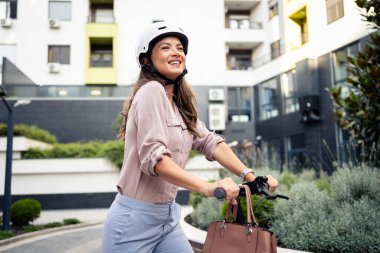 Şehirde elektrikli scooter kullanan zarif takım elbiseli güzel bir kadının portresi..